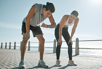 Image showing Tired couple, fitness and exercise time for performance or progress with blue sky at sea outdoor. Woman and man check watch mobile app in nature for workout, running and healthy lifestyle in summer