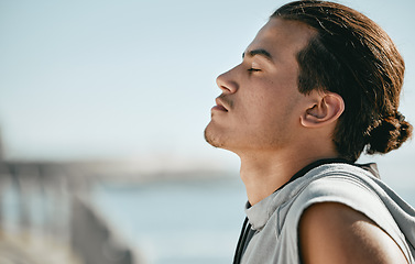 Image showing Tired, fitness and breathing man for cardio training, workout or outdoor running break on blue sky mockup. Calm, thinking and athlete or sports person with exercise in summer by beach or ocean