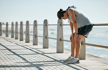Image showing Fitness, tired and breathing man for cardio training, workout or outdoor running break at beach. Breathe, thinking and fatigue of athlete or sports person with exercise challenge in summer by ocean