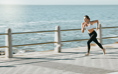 Image showing Woman, fitness and running by beach on mockup for exercise, workout or cardio routine. Active female runner in fast speed run, sprint or race by the ocean coast for healthy exercising in Cape Town