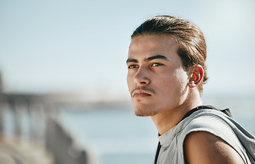 Image showing Thinking, fitness and young man at beach for cardio training, workout or running break on blue sky mockup. Calm, mindset and focus of athlete or sports person with exercise journey by ocean or sea