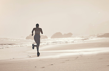 Image showing Beach, back and woman running at sunset for health, fitness and wellness outdoors alone. Sports, training and female athlete or runner on workout, exercise or cardio, jog or exercising by seashore.