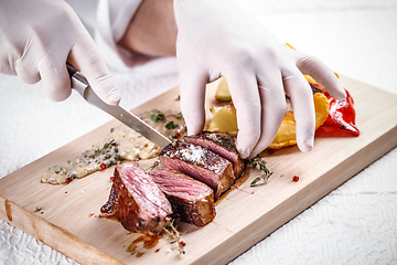 Image showing Chef cutting beef steak