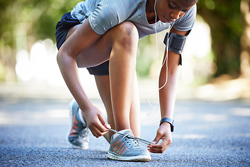 Image showing Shoes, running and athlete tie laces ready to exercise, workout or fitness outdoors in a park by female training. Active, fit and closeup of person or runner preparing to jog for health and wellness