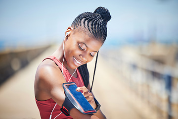 Image showing Black woman, runner and arm band with phone, earphones and motivation for outdoor fitness. Happy female athlete, mobile music and training for exercise wellness, workout energy and sports technology