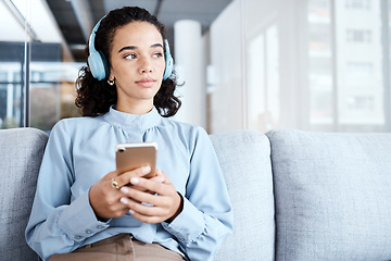 Image showing Music headphones, phone and business woman on sofa in office streaming audio. Cellphone, technology and thinking female employee on couch listening to podcast, radio or sound with mobile smartphone.