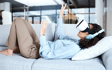 Image showing Virtual reality, metaverse and gamer with a black woman on a sofa in the living room of her home. AI, 3D and VR with a young female gaming using a headset to access cyberspace for a video game