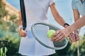 Image showing Tennis training, hands and ball with women and athlete on outdoor turf, instructor or coach, fitness motivation and help. Exercise, sports lesson and workout together, teaching and learn on court