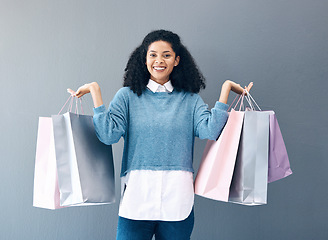 Image showing Shopping, black woman and portrait of a happy customer with bags after boutique or shop sale. Isolated, gray background and female smile in a studio holding a bag with discount market product