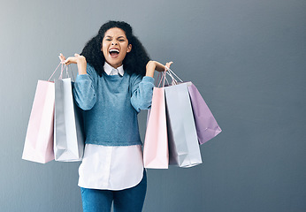 Image showing Shopping, black woman excited and scream portrait of a happy customer with bags after shop sale. Isolated, gray background and female smile in a studio holding a bag with discount market product