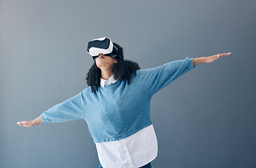 Image showing Metaverse, virtual reality headset and gaming black woman with hands for 3d flying game in studio. Gamer person vr glasses in digital world, futuristic app and ar tech ux experience grey background