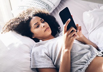 Image showing Black woman, sad and typing with phone on bed in home bedroom for social media or internet browsing in the morning. Technology, bored and lonely female with mobile for web scrolling or networking.