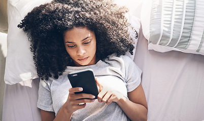 Image showing Phone, black woman and top view in home bedroom for social media, texting or internet browsing in the morning. Technology, bed relax and female with mobile smartphone for web scrolling or networking.