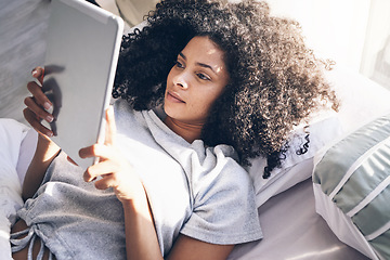 Image showing Tablet, black woman and relax in bed in bedroom for social media, texting or internet browsing in the morning. Technology, home and female with digital touchscreen for web scrolling after waking up.