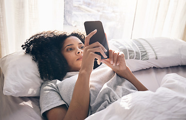 Image showing Phone, black woman and typing in home bedroom for social media, texting or internet browsing in the morning. Technology, bed relax and female with mobile smartphone for web scrolling or networking.