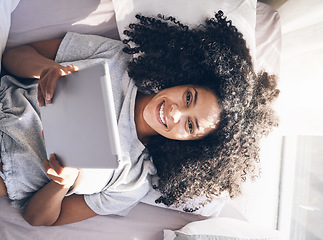 Image showing Tablet, black woman and top view in bed in bedroom for social media, texting or internet browsing in the morning. Portrait, relax and female on digital touchscreen for web scrolling or networking.