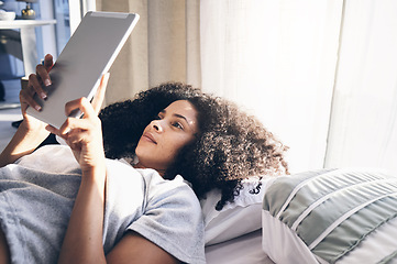 Image showing Tablet, black woman and relax in bed in bedroom for social media, texting or internet browsing in the morning. Technology, home and female with digital touchscreen for web scrolling after waking up.