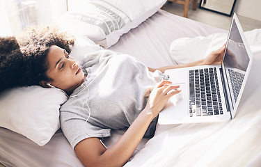 Image showing Music earphones, woman and laptop in bed in bedroom for social media or internet browsing in the morning. Technology, relax or black female with computer for streaming podcast, audio or radio in home