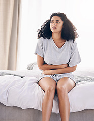 Image showing Black woman, sick and stomach ache on house bed, home or bedroom in period pain, menstruation cramps or ibs crisis. Hurt person, injury and abdomen tummy in healthcare emergency or appendicitis risk