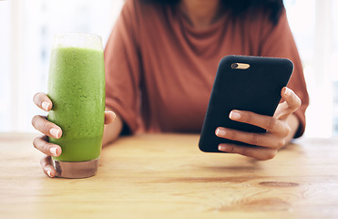 Image showing Hands, glass and phone with a black woman in the kitchen of her home for health, weight loss or nutrition. Mobile, smoothie and wellness with a female posting a status update on social media