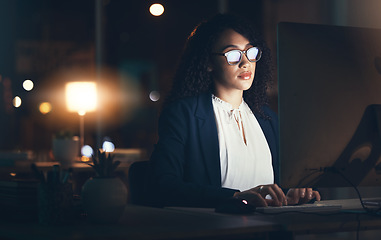Image showing Serious, night and business black woman on computer for planning, project management and research. Dark office, overtime and female worker focus working on strategy, reading website and typing email