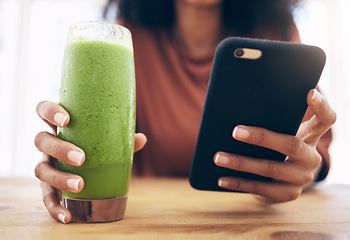 Image showing Hands, smoothie and phone with a black woman in the kitchen of her home for health, weight loss or nutrition. Mobile, glass and wellness with a female posting a status update on social media