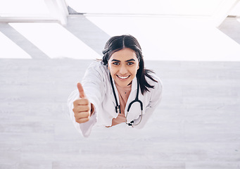 Image showing Top view, portrait or doctor thumbs up for success, vote or clinic approval for hospital life insurance or winner trust on mock up. Smile, happy or yes hands for healthcare worker woman in wellness