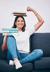 Image showing Portrait, education and success with a student woman flexing her bicep while sitting on a sofa in her home. University, books and balance with an attractive young female pupil feeling confident