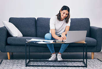 Image showing Woman, laptop and writing notes on living room sofa in remote work or studying on table at home. Female freelancer working with smile for planning, strategy or notebook by computer sitting on couch