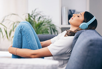 Image showing Music, relax and quiet with a woman in her home, listening to the radio while sitting on the living room sofa. Peace, wellness or headphones with an attractive young female streaming audio in a house