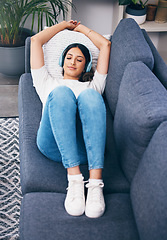 Image showing Music, relax and lying with a woman in her home, listening to the radio while on a sofa in the living room. Peace, wellness or headphones with an attractive young female streaming audio in a house