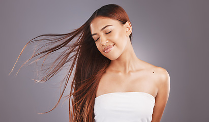 Image showing Happy, hair and hairstyle by woman with smooth, glow and healthy skincare isolated in a studio gray background. Young, skin and natural model smile due to keratin treatment for haircare