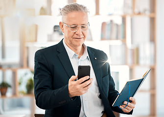 Image showing Notebook, phone and senior business man in office for client contact, reading directory and planning schedule. Social media, networking and ceo on smartphone for mobile app, writing email and text