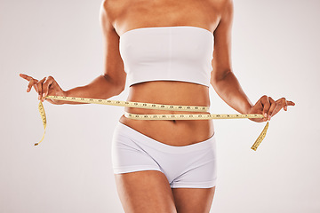 Image showing Weight, loose and woman with tape for stomach isolated on a grey studio background. Diet, health and girl measuring her waist for slim shape, motivation and belly while standing on a backdrop