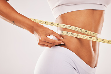 Image showing Weight, fat and woman with tape for stomach isolated on a grey studio background. Insecurity, health and girl measuring her body for slim shape, cellulite and belly while standing on a backdrop