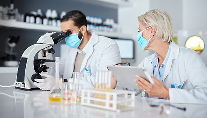 Image showing Scientist teamwork, lab and tablet covid 19 vaccine research for company with mask, studying and pharma. Man, woman and science with microscope analysis, tech and medical goals for healthcare future