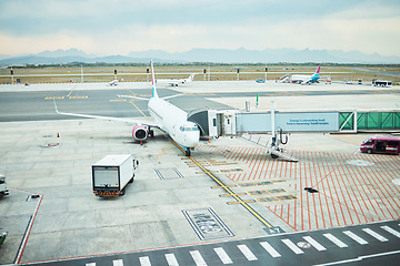 Image showing Airplane at airport, stationary aircraft on tarmac and runway for international passenger travel on sky horizon. Plane on ground, outdoor flight terminal and cargo carrier on aeroplane runway