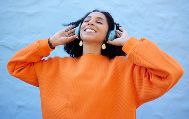 Image showing Black woman, headphones and listen to music, freedom to relax with wellness and audio streaming. Happiness, care free with radio or podcast, mindset and peace of mind with playlist on blue background