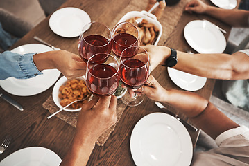 Image showing Top view, hands and toast with red wine at dinner table for new year celebration in home. Party, cheers and group of friends, men and woman with alcohol or beverage to celebrate with delicious food.