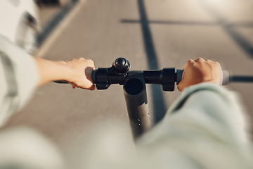 Image showing Electric scooter, travel and person hands driving on urban street for eco friendly journey to university. Carbon footprint, speed or fast moving student on energy saving transport for college in POV