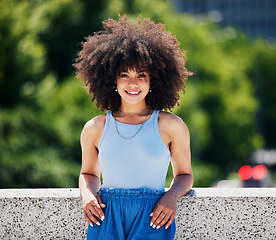 Image showing Portrait, fashion and city bridge with a black woman outdoor, looking relaxed during a summer day. Street, style or urban and an attractive young female posing outside with an afro hairstyle