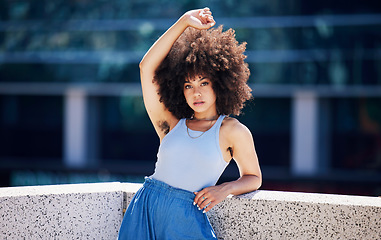 Image showing Portrait, fashion and trendy with a black woman in the city on a bridge, looking relaxed during summer. Street, style or urban and a natural young female posing outside with an afro hairstyle