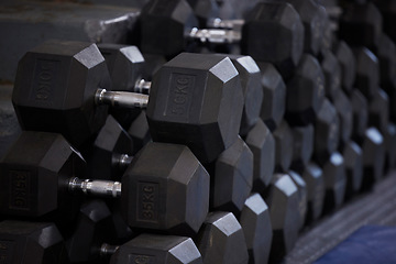 Image showing Fitness, workout and dumbbells in empty gym for exercise, bodybuilding development and sports training club. Background zoom of heavy steel weights, equipment and iron for lifting in wellness studio