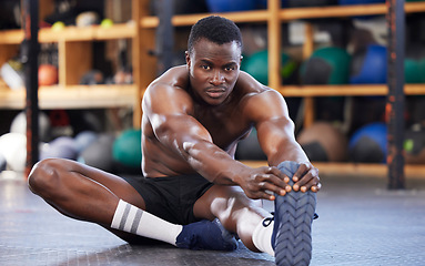 Image showing Stretching, training and portrait of black man in gym for sports, workout and performance. Wellness, exercise and fitness with athlete and warm up legs on floor for cardio, endurance and energy