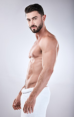 Image showing Muscular man, standing and smile with towel for clean hygiene, wash or skincare isolated on gray studio background. Portrait of attractive male model smiling for fit body, cosmetics or fresh grooming