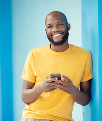 Image showing Black man, portrait or phone typing on blue background, mockup or wall mock up on social media, internet app or blogging. Smile, happy person or fashion clothes on mobile technology for trendy ideas