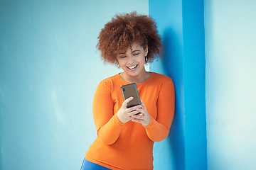 Image showing Black woman, cellphone and laughing on mobile on blue wall of social media, technology or network. Happy young girl typing on smartphone of connection, reading funny notification and meme post online