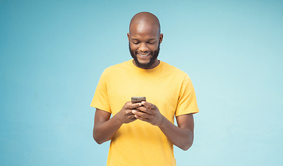 Image showing Black man, phone or typing on blue background, isolated mockup or wall mock up on social media, internet app or blogging. Smile, happy person or fashion clothes on mobile technology for trendy ideas