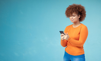 Image showing Woman, cellphone connection and mockup on blue background for social media, website and network. Young female typing on mobile technology in studio for online advertising, marketing app and contact