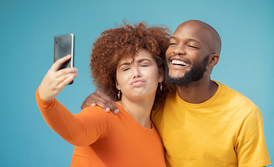 Image showing Couple, bonding or funny faces selfie on blue background, isolated mockup or wall mock up on social media. Comic, goofy or silly man and woman on photography technology in interracial profile picture